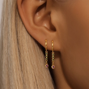 Macro shot of S925 silver gold-plated earrings with green and purple gemstones