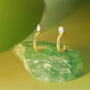 Macro shot of asymmetrical S925 sterling silver C-shaped stud earrings with zircons