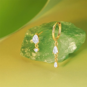 Asymmetric gold earrings with cat eye stones and cubic zirconia on green crystal stones