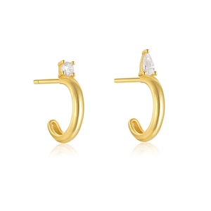 Macro detail of asymmetric C-shape earrings with gold plating and cubic zirconia stones