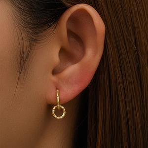 Macro shot of gold double hoop earrings with pave-set zircon stones on model