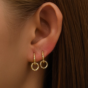 Detail of elegant gold double hoop earrings with cubic zirconia on a female model