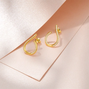 Macro detail of gold J-shaped S925 silver earrings with pave-set zircon stones