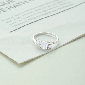 Macro shot of S925 sterling silver three-stone ring featuring clear hallmarks and pavé setting