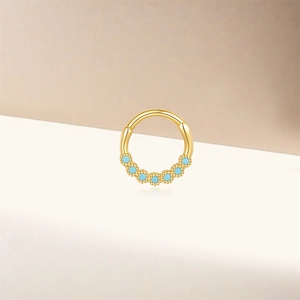 Detailed macro view of 925 silver gold piercing ring with seven turquoise stones