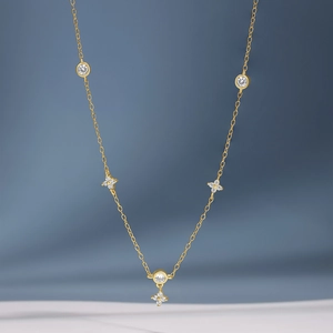 Detalle de collar en plata S925 dorada con colgantes de flores de circonitas brillantes