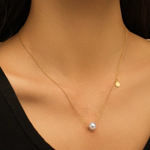 Primer plano del collar de plata S925 dorada con perla blanca y colgante redondo