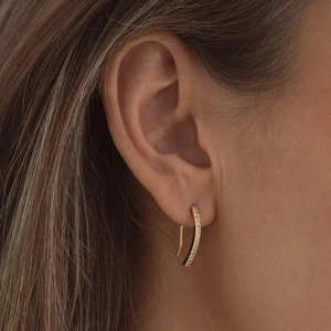 Close-up of gold S925 silver curved drop earrings with pavé zircons on model ear