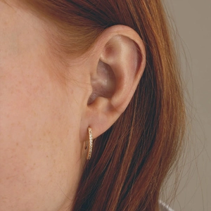 Detail of S925 silver gold-plated ear cuff with sparkling row of cubic zirconia stones
