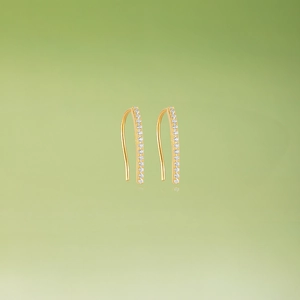 Macro shot of minimalist S925 silver curved drop earrings with micro-set zircon accents