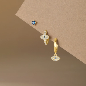 Macro shot of 3-piece S925 silver evil eye earring set with blue stones and gold plating