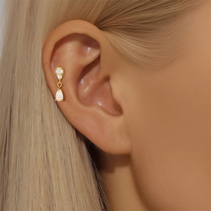 Macro shot of S925 silver gold-plated opal and zircon flat back helix piercing earring