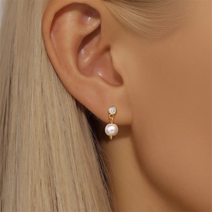 Close-up of S925 silver ear stud featuring a marquise opal and pearl on a model