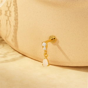 Macro shot of gold s925 silver clover stud earring with sparkling cubic zirconia and opal