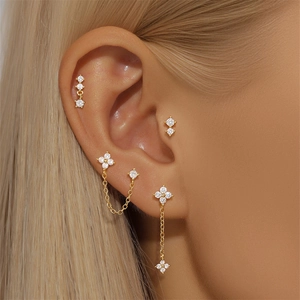 Primer plano del set de pendientes de trébol en plata S925 dorada con circonitas brillantes