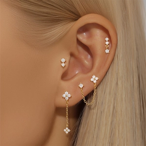 Vista macro de pendientes de trébol en plata S925 dorada con circonitas brillantes en oreja