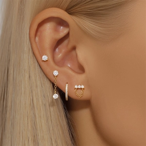 Detalle macro de pendientes de trébol en plata S925 con circonitas en una modelo