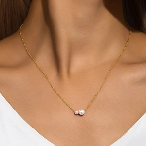 Detalle de collar ajustable de plata S925 dorada con dos perlas en una modelo