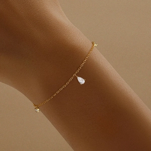 Primo piano di un bracciale in argento S925 dorato con ciondoli in zircone a goccia