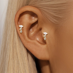 Close-up van S925 zilveren vergulde kraakbeenknopjes met marquise zirkoon op de tragus