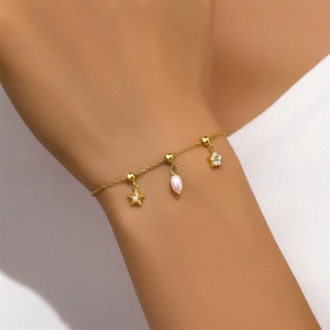 Détail du bracelet en argent S925 avec perle, fleur en zircon et breloques en étoile