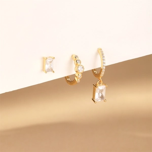 Détail d'un ensemble de trois boucles d'oreilles en argent doré et pierres brillantes