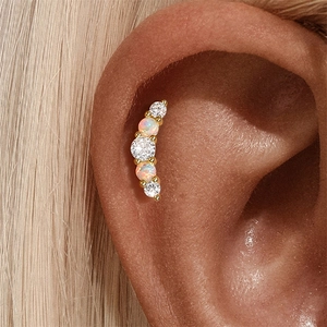 Close-up of S925 silver ear cartilage stud with opals and zircons on gold plating