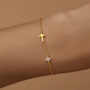 Detaillierte Makroansicht eines vergoldeten S925 Silberarmbands mit Kreuz und Zirkon-Klee