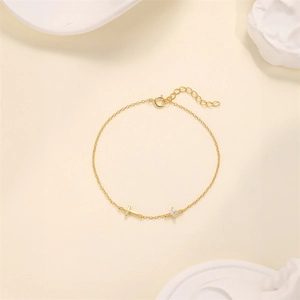 Detail von goldenem Kreuz und Zirkon-Blume auf s925 Sterling Silber Kettenarmband