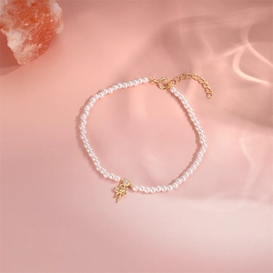 Detailansicht eines S925 Silber-Perlenarmbands mit goldener Schleife und Diamantakzent