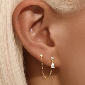Macro shot of 925 sterling silver gold plated chain earring with teardrop zircon pendant
