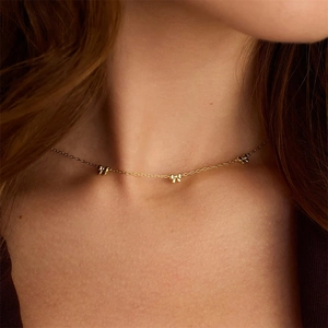 Gros plan d'un élégant collier en argent S925 à nœud doré porté sur le cou d'une femme