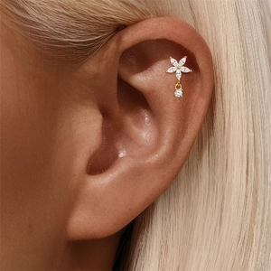 Detail of gold flower tragus stud with marquise opal petals on a model ear