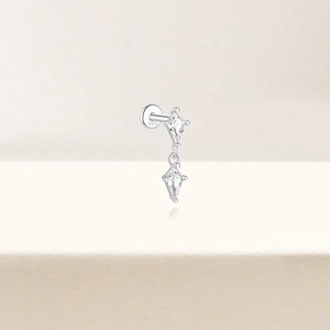 Macro detail of 925 sterling silver piercing stud with dangling kite-shaped cubic zirconia