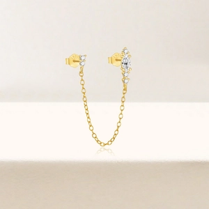 Close-up of S925 sterling silver stamp on golden chain earrings with sparkling zircons