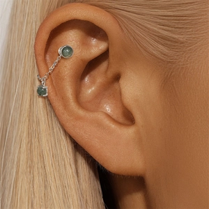 Detail of s925 silver earring chain with green moss agate stones worn on ear cartilage