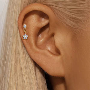 Close-up of S925 silver opal flower cartilage stud earring worn on a model ear