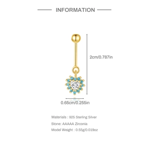 Detail van 925 zilveren gouden navelpiercing met hart-zirkonia en blauwe kraalaccenten