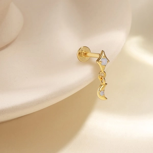 Close-up of gold S925 silver stud earrings with opal moon and star fringe details