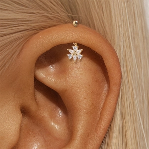 Detailopname van een s925 zilveren helix piercing met zirkonia bloem op een model oor
