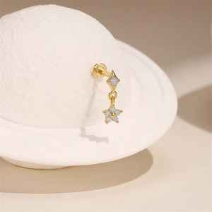 Macro view of gold-plated S925 silver stud earrings with light blue opal star and diamond shapes