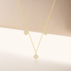 Macro detail of gold S925 clover pendant necklace with sparkling cubic zirconia stones