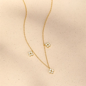 Detail of gold four-leaf clover necklace with bezel-set cubic zirconia charms