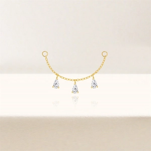 Detail of gold chain earring accessory with three pear-cut cubic zirconia drops