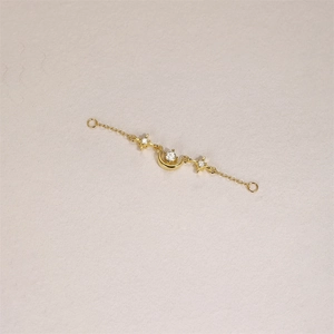 Macro detail of S925 silver 18K gold star and crescent moon chain with cubic zirconia