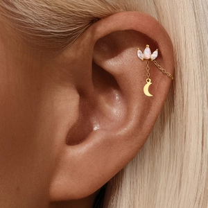 Close-up of gold chain earring with opal, marquise zircon and a crescent moon pendant