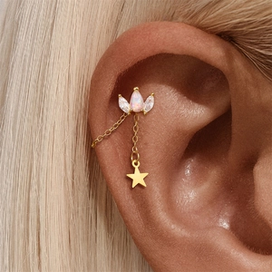 Macro view of gold crown ear cuff with opal stone and dangling star chain detail
