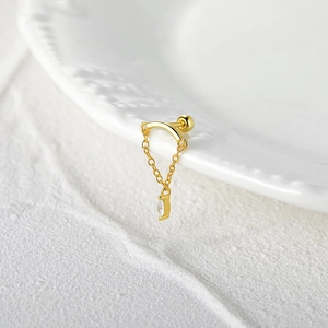 Goldener S925 Silber Kettenohrring mit Marquise-Kristall auf weißem Keramikhintergrund