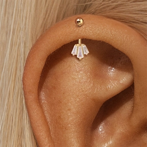 Detailopname van gouden rook-piercing met drie waaiervormige trapeze-zirkonia