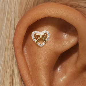 Gros plan d'une boucle d'oreille cœur en argent s925 avec nœud et zircons sertis